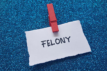 Word "Felony" written on a note.