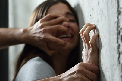 Image depicts a person's mouth being covered by a hand, suggesting a legal topic of assault