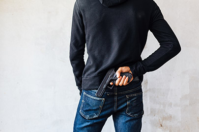 Person hiding a handgun behind their back for Texas deadly weapon assault charge enhancement.